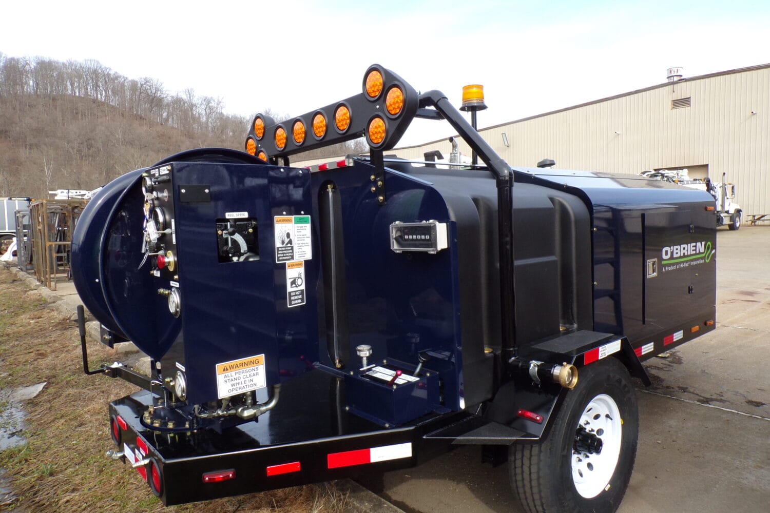 O'Brien Sewer Jetters single-axle trailer sewer jetter with hose reel, control panel, and amber beacons at the factory.