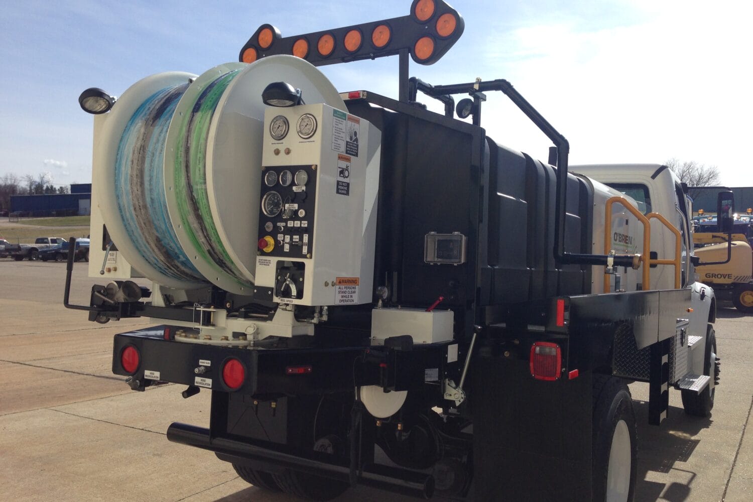 O'Brien Sewer Jetters truck-mounted unit with dual hose reels, control panel, and water tank ready for sewer cleaning.