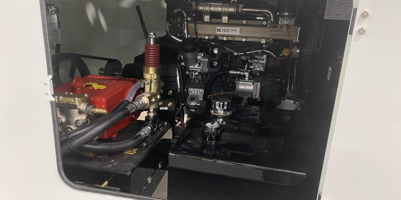 Open compartment showing O'Brien Sewer Jetters power pack with Kohler engine and red high‑pressure jetter pump.